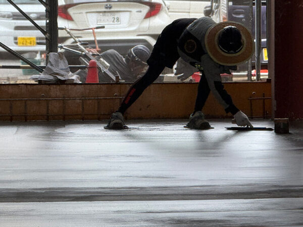 職人がコンクリートの最終仕上げを行う様子