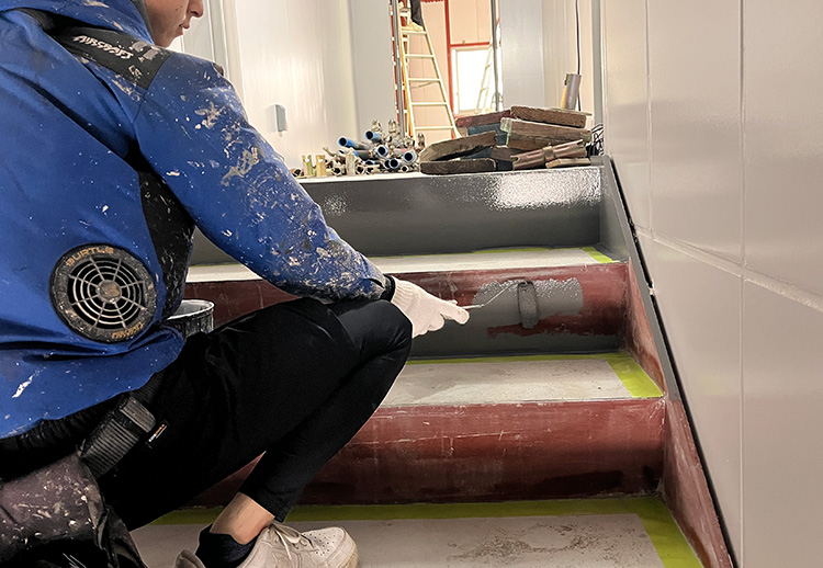 階段を塗装する職人